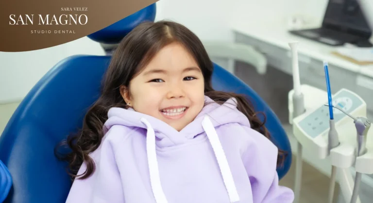 Niña sonriendo relajada en el sillón dental mientras la doctora le muestra un espejo, preparándose para su tratamiento de ortodoncia Twin Block infantil en Altea.